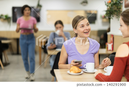 In cafe, woman chatting sweetly during tea party with girl buddy In cafe, woman chatting sweetly during tea party with girl buddy 140291900