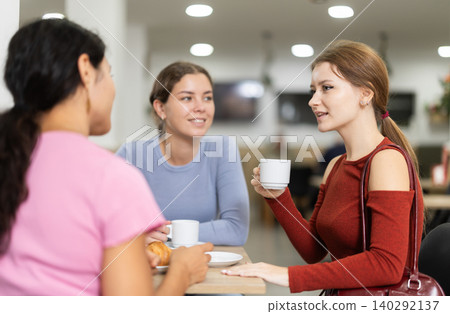 Three girls are chatting sweetly during tea party Three girls are chatting sweetly during tea party 140292137