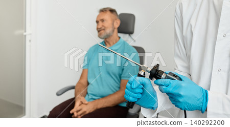 Ear endoscopy. ENT doctor examining senior man's ear using video endoscope at otolaryngology clinic 140292200