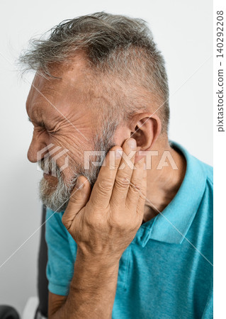 Hearing loss. Senior man with hearing problems touching ear with hand. Side view, earache Hearing loss. Senior man with hearing problems touching ear with hand. Side view, earache 140292208