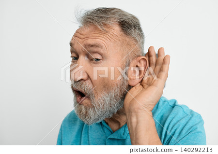 Close-up headshot of elderly man holding hand near his ear, isolated over white background. Hearing solutions Close-up headshot of elderly man holding hand near his ear, isolated over white background. Hearing solutions 140292213