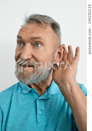 Elderly man's hand near his ear, which he has placed to his ear to better hear voices and sounds. Hearing problems in elderly Elderly man's hand near his ear, which he has placed to his ear to better hear voices and sounds. Hearing problems in elderly 140292216