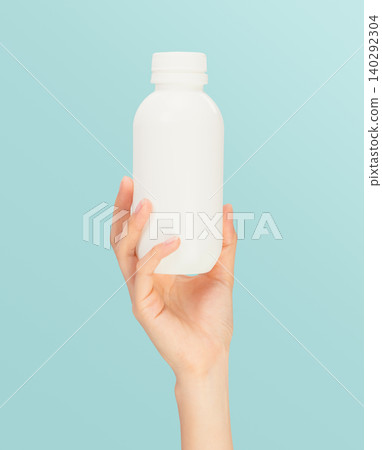 Hand holding medicine bottle on blue background, healthcare and treatment concept. 140292304