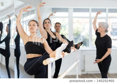 Students of dance studio perform exercises under supervision of mature female coach 140292460