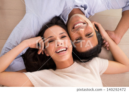 Portrait, smile and top view of couple holding hands on floor to relax together in home. Above, man and face of happy woman bonding for connection, love or support for healthy relationship in house Portrait, smile and top view of couple holding hands on floor to relax together in home. Above, man and face of happy woman bonding for connection, love or support for healthy relationship in house 140292472