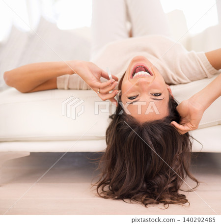 Excited, phone call and portrait of woman on sofa upside down for conversation with contact. Face, smartphone and funny person in living room listening to joke, comedy and laughing at story in home 140292485