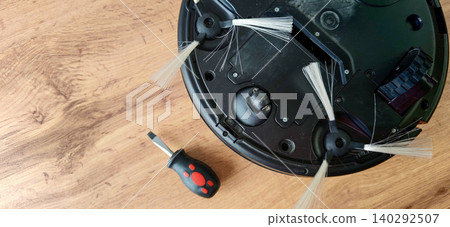 Robot vacuum cleaner with disassembled brush components and screwdriver on wooden surface, showcasing maintenance and repair process for home cleaning devices Robot vacuum cleaner with disassembled brush components and screwdriver on wooden surface, showcasing maintenance and repair process for home cleaning devices 140292507