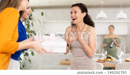 Two women have arrived for birthday celebration and presenting gift to birthday woman Two women have arrived for birthday celebration and presenting gift to birthday woman 140292765