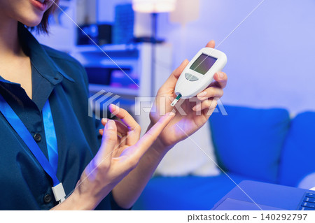 Young Asian woman checking blood sugar level with glucose meter, diabetes monitoring and healthcare concept. Young Asian woman checking blood sugar level with glucose meter, diabetes monitoring and healthcare concept. 140292797