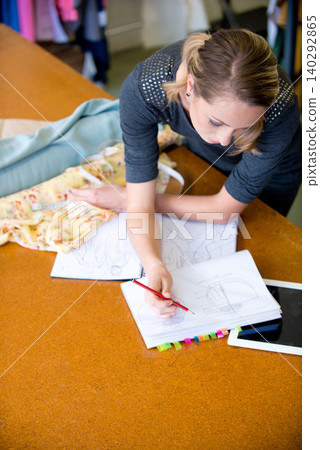 Fashion designer and drawing costume design with style, artistic or inspiration at desk with mockup. Pencil, female person or fabric with stylish, fashionable or pattern for clothing with creativity Fashion designer and drawing costume design with style, artistic or inspiration at desk with mockup. Pencil, female person or fabric with stylish, fashionable or pattern for clothing with creativity 140292865