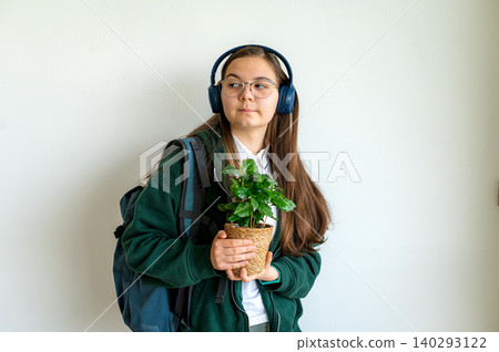 Teenage student holding her plant on white background Teenage student holding her plant on white background 140293122
