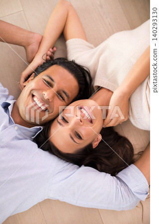Portrait, smile and top view of couple on floor, holding hands and relax together in home. Above, man and face of happy woman bonding for connection, love or support for healthy relationship in house Portrait, smile and top view of couple on floor, holding hands and relax together in home. Above, man and face of happy woman bonding for connection, love or support for healthy relationship in house 140293130