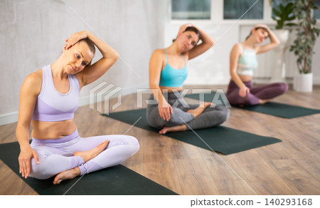Young woman doing neck stretching exercise in Padmasana pose Young woman doing neck stretching exercise in Padmasana pose 140293168