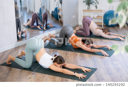 Young woman practicing stretching at group yoga class at studio 140293292