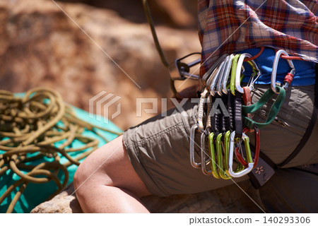Person, harness and gear on mountain for rock climbing with safety equipment on waist in nature. Closeup of hiker or climber with rope, strap or cable hooks for trekking, fitness or extreme sports Person, harness and gear on mountain for rock climbing with safety equipment on waist in nature. Closeup of hiker or climber with rope, strap or cable hooks for trekking, fitness or extreme sports 140293306