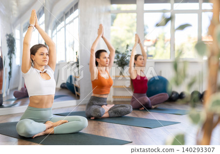 Girl teacher conducts lesson, training for girls in yoga studio and performs lotus pose Girl teacher conducts lesson, training for girls in yoga studio and performs lotus pose 140293307