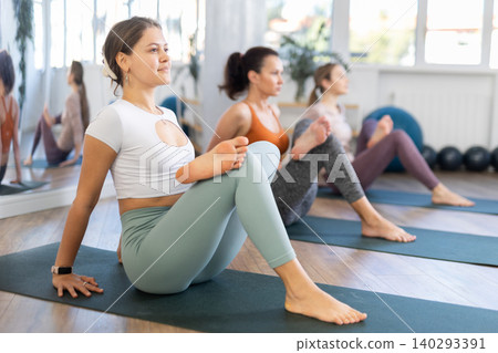 Women performing yoga exercises during group training at gym. Fitness and Hatha yoga concept 140293391