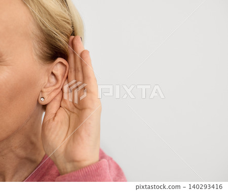 Mature woman listening sound with hand near ear for hearing check-up. Hearing test concept 140293416