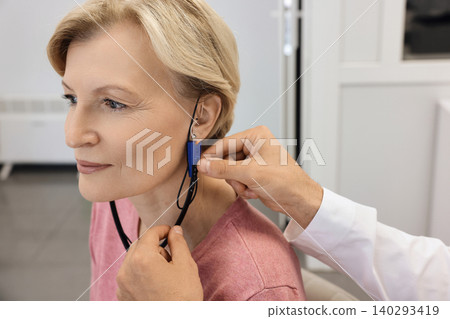 Audiology. Specialized audiological equipment is being used to adjust a hearing aid for an individual during a fitting session Audiology. Specialized audiological equipment is being used to adjust a hearing aid for an individual during a fitting session 140293419