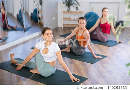 Girl teacher lead lesson, run training in female yoga studio and performs snail pose Girl teacher lead lesson, run training in female yoga studio and performs snail pose 140293583