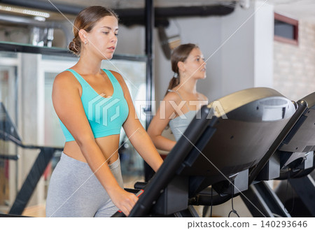 Young woman exercising on treadmill in gym Young woman exercising on treadmill in gym 140293646
