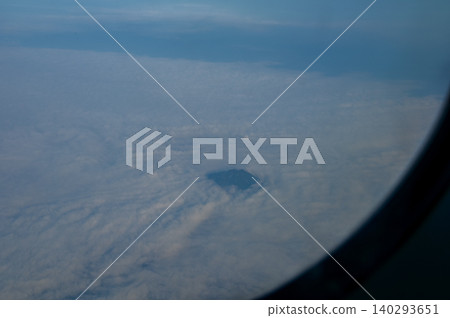 The view of the stunning landscape with mountains and clouds from the airplane window. Aerial view of the natural scene, mountain range. Travel and landscape scene. Travel and nature concept. The view of the stunning landscape with mountains and clouds from the airplane window. Aerial view of the natural scene, mountain range. Travel and landscape scene. Travel and nature concept. 140293651