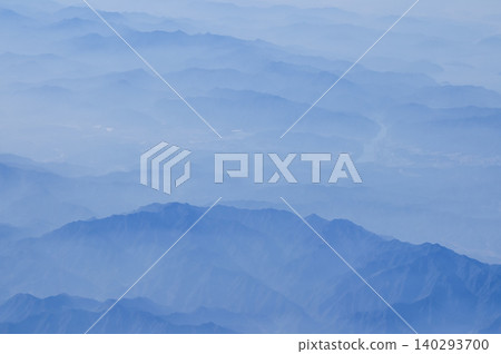 The view of the stunning landscape with mountains and clouds from the airplane window. Aerial view of the natural scene, mountain range. Travel and landscape scene. Travel and nature concept. The view of the stunning landscape with mountains and clouds from the airplane window. Aerial view of the natural scene, mountain range. Travel and landscape scene. Travel and nature concept. 140293700