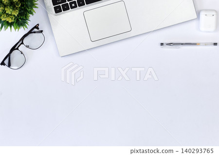 Minimalist workspace with sleek gadgets. Green phone rests beside laptop and mouse. White earbuds and pen add functional touch. Clean desk invites calm, focused productivity Minimalist workspace with sleek gadgets. Green phone rests beside laptop and mouse. White earbuds and pen add functional touch. Clean desk invites calm, focused productivity 140293765