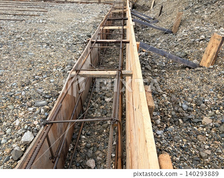 The steel reinforcement frame is carefully installed, preparing the foundation for pouring concrete. 140293889