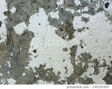 Old worn white paint texture on a stone wall. Close-up view of a deteriorating wall surface, likely made of concrete or stucco. Old worn white paint texture on a stone wall. Close-up view of a deteriorating wall surface, likely made of concrete or stucco. 140293897