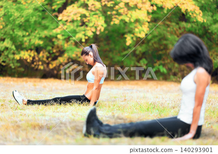 Women, stretching and yoga outdoor in nature for wellness, peace of mind and fitness in garden. Muscle, exercise and calm people in park for energy, balance and strength with warm up on grass Women, stretching and yoga outdoor in nature for wellness, peace of mind and fitness in garden. Muscle, exercise and calm people in park for energy, balance and strength with warm up on grass 140293901