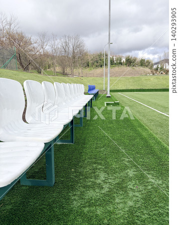 an open-air football stadium with a green lawn and empty rows of seats for spectators an open-air football stadium with a green lawn and empty rows of seats for spectators 140293905