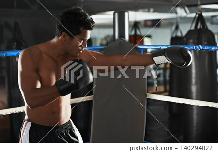 Punch, man and boxing ring for sports, exercise or competition in gym for body health. Fighter, serious and strong athlete with gloves for fitness, training or workout to practice with fist at club Punch, man and boxing ring for sports, exercise or competition in gym for body health. Fighter, serious and strong athlete with gloves for fitness, training or workout to practice with fist at club 140294022