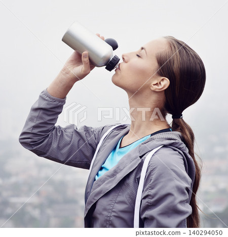 Woman, drink and water bottle for fitness, detox and wellness on cloudy day in France with mockup. Thirsty female person, sportswear and hydrate with exercise, training and workout for health 140294050