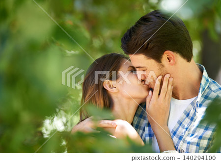 Couple, garden and kiss with love for date, bonding and romance with embrace in nature park. Man, woman and happy relationship with affection in summer for vacation, weekend or travel together Couple, garden and kiss with love for date, bonding and romance with embrace in nature park. Man, woman and happy relationship with affection in summer for vacation, weekend or travel together 140294100