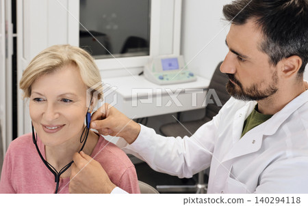 Audiologist customizes a hearing aid to improve an individual's audio experience with advanced techniques. Real ear measurements Audiologist customizes a hearing aid to improve an individual's audio experience with advanced techniques. Real ear measurements 140294118