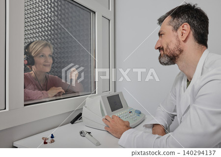 Mature woman getting a hearing test at audiology center. Audiometry, hearing check up Mature woman getting a hearing test at audiology center. Audiometry, hearing check up 140294137