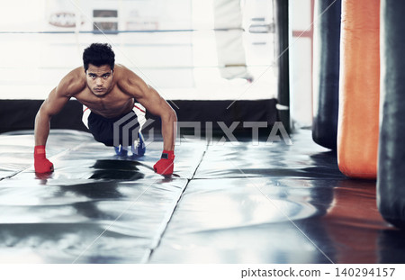 Athlete, portrait and push ups for sports in gym for training, wellness and workout for body. Man, exercise and gloves on hands, muscle and health for person in fitness centre, strong and serious 140294157