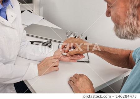 Hearing doctor consultation. Female audiologist doing consultation for grey-haired senior man patient with hear problems at hearing center Hearing doctor consultation. Female audiologist doing consultation for grey-haired senior man patient with hear problems at hearing center 140294475