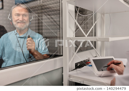 Elderly man getting a hearing test at audiology center. Audiometry, hearing check up 140294479