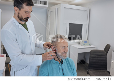 Audiology. Specialized audiological equipment is being used to adjust a hearing aid for an individual during a fitting session Audiology. Specialized audiological equipment is being used to adjust a hearing aid for an individual during a fitting session 140294515