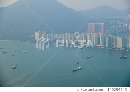 Looking from the airplane window with Hong Kong cityscape. The view of Hong Kong city, Hong Kong landscape from the above. Landscape, travel concept and nature scene. Looking from the airplane window with Hong Kong cityscape. The view of Hong Kong city, Hong Kong landscape from the above. Landscape, travel concept and nature scene. 140294543