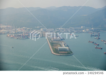 Looking from the airplane window with Hong Kong cityscape. The view of Hong Kong city, Hong Kong landscape from the above. Landscape, travel concept and nature scene. Looking from the airplane window with Hong Kong cityscape. The view of Hong Kong city, Hong Kong landscape from the above. Landscape, travel concept and nature scene. 140294546