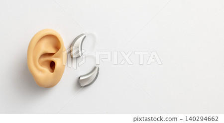 Hearing aid next to a lifelike ear model highlights the significance of hearing technology in hearing treatment Hearing aid next to a lifelike ear model highlights the significance of hearing technology in hearing treatment 140294662