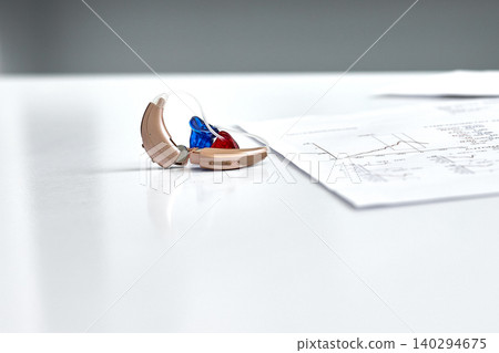 Behind-the-ear hearing aids with colored inserts are individually selected for patient after a precise hearing acuity assessment using tympanometry and audiometry Behind-the-ear hearing aids with colored inserts are individually selected for patient after a precise hearing acuity assessment using tympanometry and audiometry 140294675