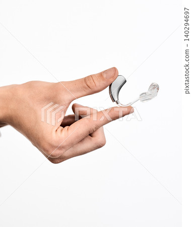 Doctor holding last generation of hearing aid device for human ear, isolated on white Doctor holding last generation of hearing aid device for human ear, isolated on white 140294697