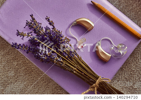 Colorful hearing aids await amid fragrant lavender and a pencil, inspiring connection and creativity Colorful hearing aids await amid fragrant lavender and a pencil, inspiring connection and creativity 140294710