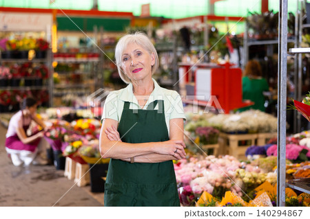 Portrait of benevolent owner of flower market against the background of bouquets and potted flowers 140294867