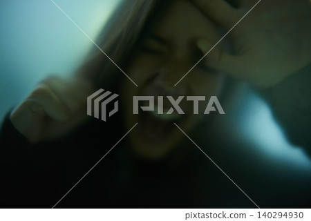 Scary, scream and woman with hand on glass, window or person trapped in home. Girl, shadow and figure in horror, drama or creepy aesthetic with angry shouting from terror in house with fog on screen Scary, scream and woman with hand on glass, window or person trapped in home. Girl, shadow and figure in horror, drama or creepy aesthetic with angry shouting from terror in house with fog on screen 140294930