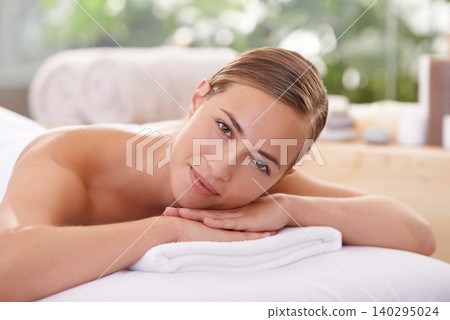 Woman, spa and massage table for wellness, health and self care for relaxation and portrait and therapy. Female person, luxury resort and body treatment for serenity skincare and detox to destress 140295024